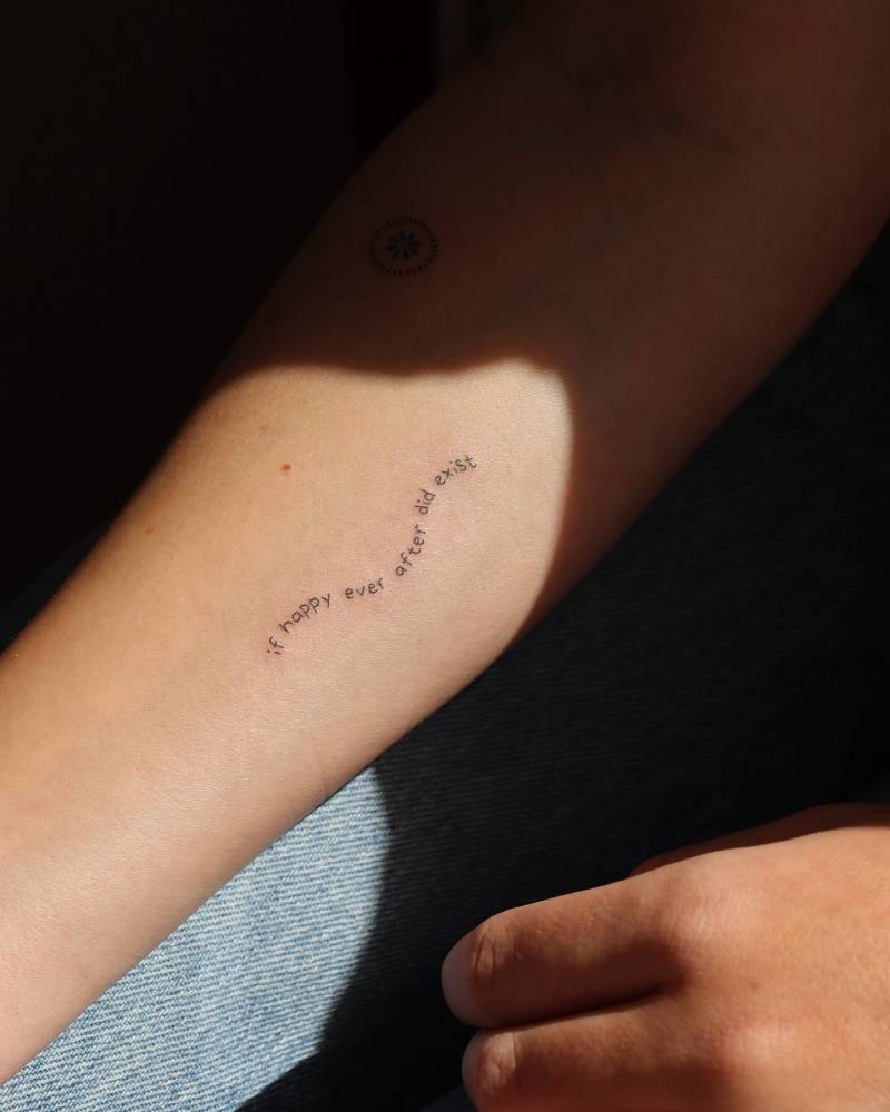 "If happy ever after did exist" lettering tattoo placed on the inner forearm.