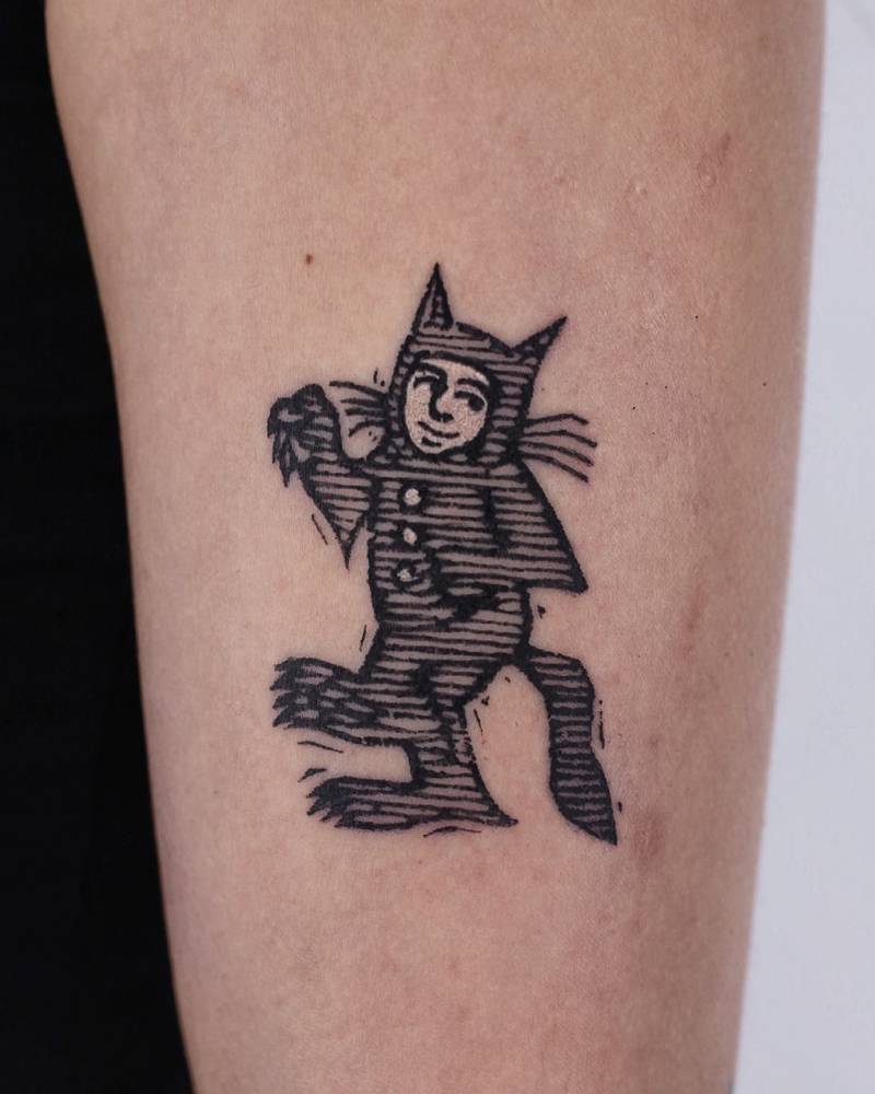Cartoon style Where the Wild Things Are tattoo located on the upper arm.