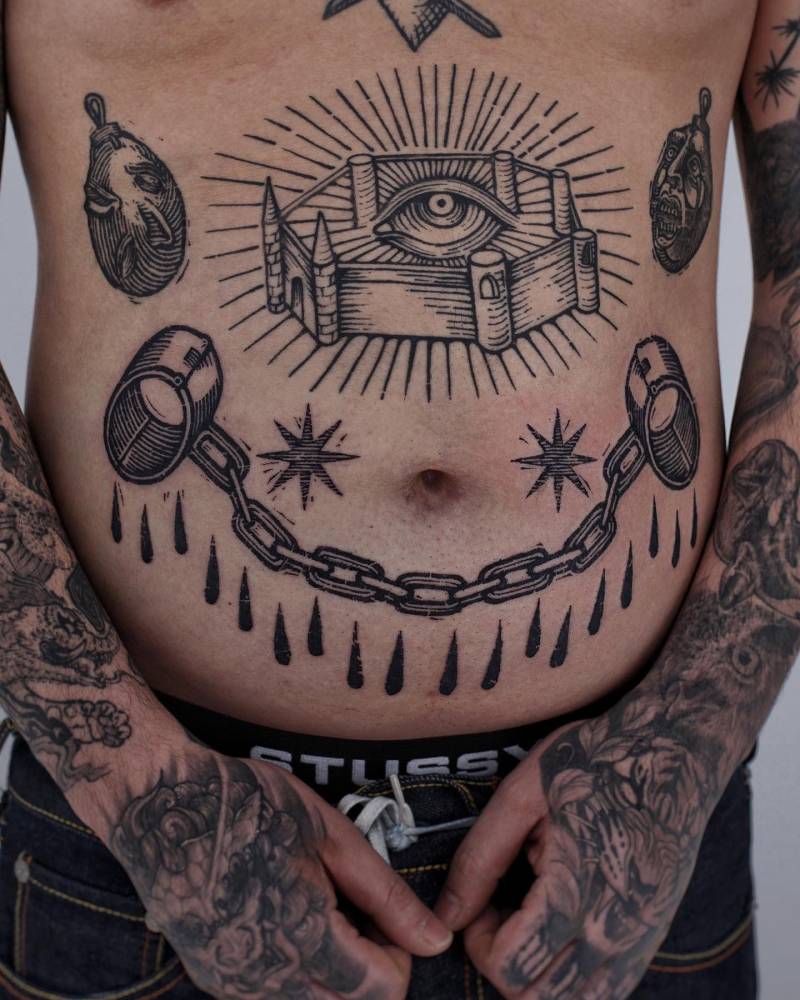 Engraving style handcuffs tattoo located on the stomach.