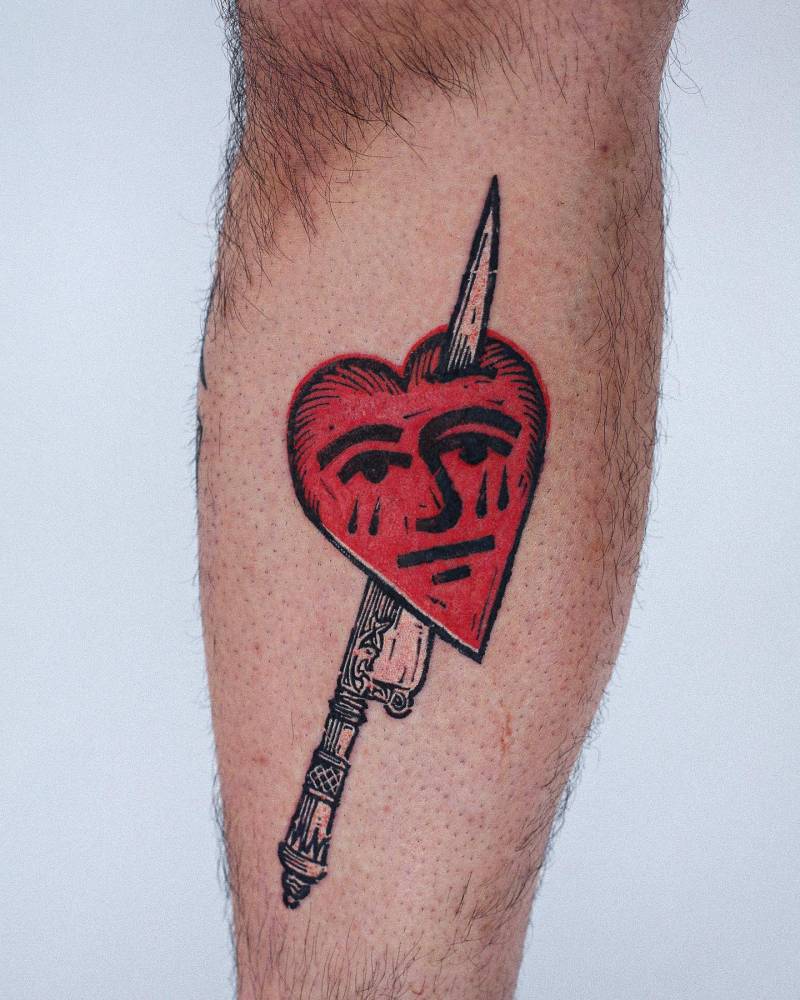 Knife and crying heart tattoo located on the shin, engraving style.
