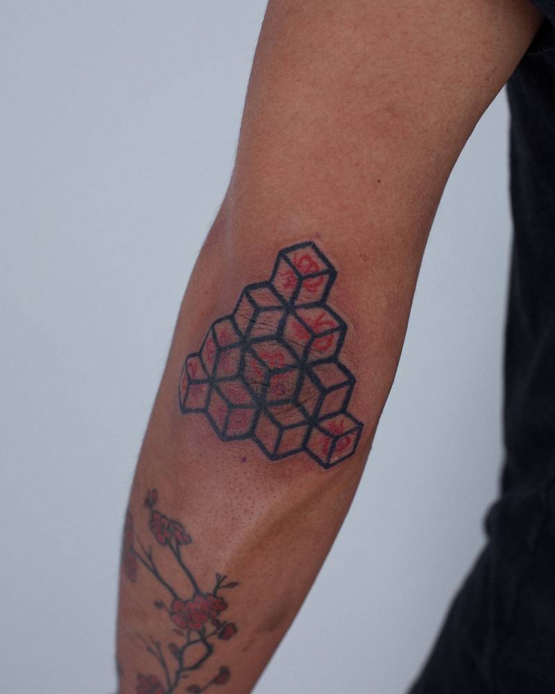 Cubes tattoo in illustrative style located on the elbow.