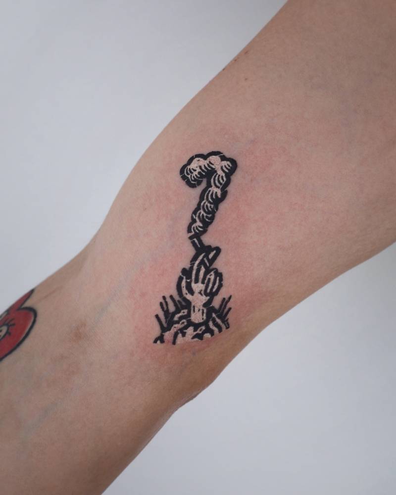 Hand holding a cigarette tattooed on the inner arm, pop art style.