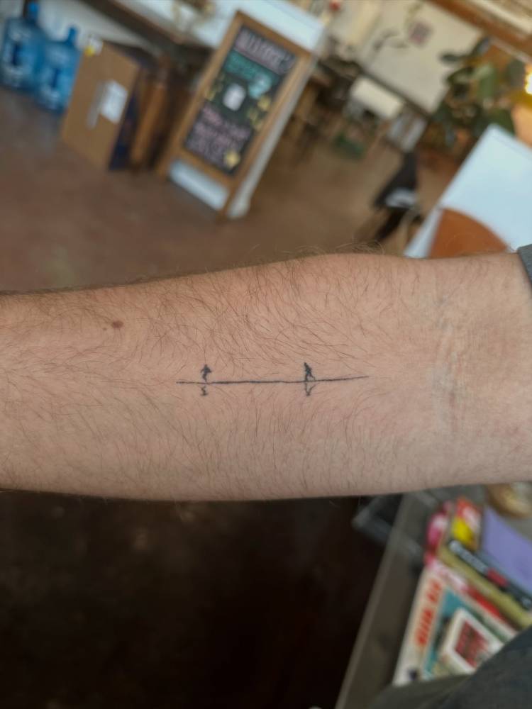 Healed 'Normal People' still shot tattoo located on the inner forearm.