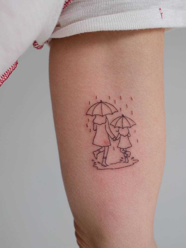 Mother and daughter in the rain tattooed on the inner arm.