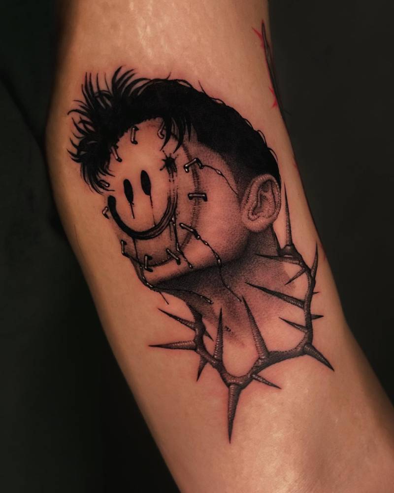 Smiley mask tattoo in comic style located on the inner arm.