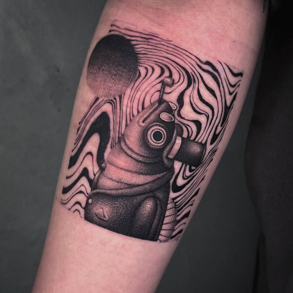 Surrealistic style dandy fish tattoo located on the inner forearm.