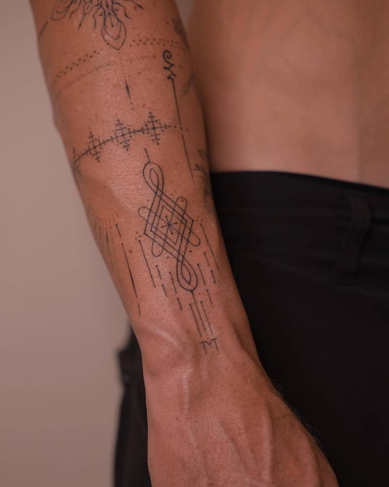 Hand poked ornamental tattoo composition done on the forearm.