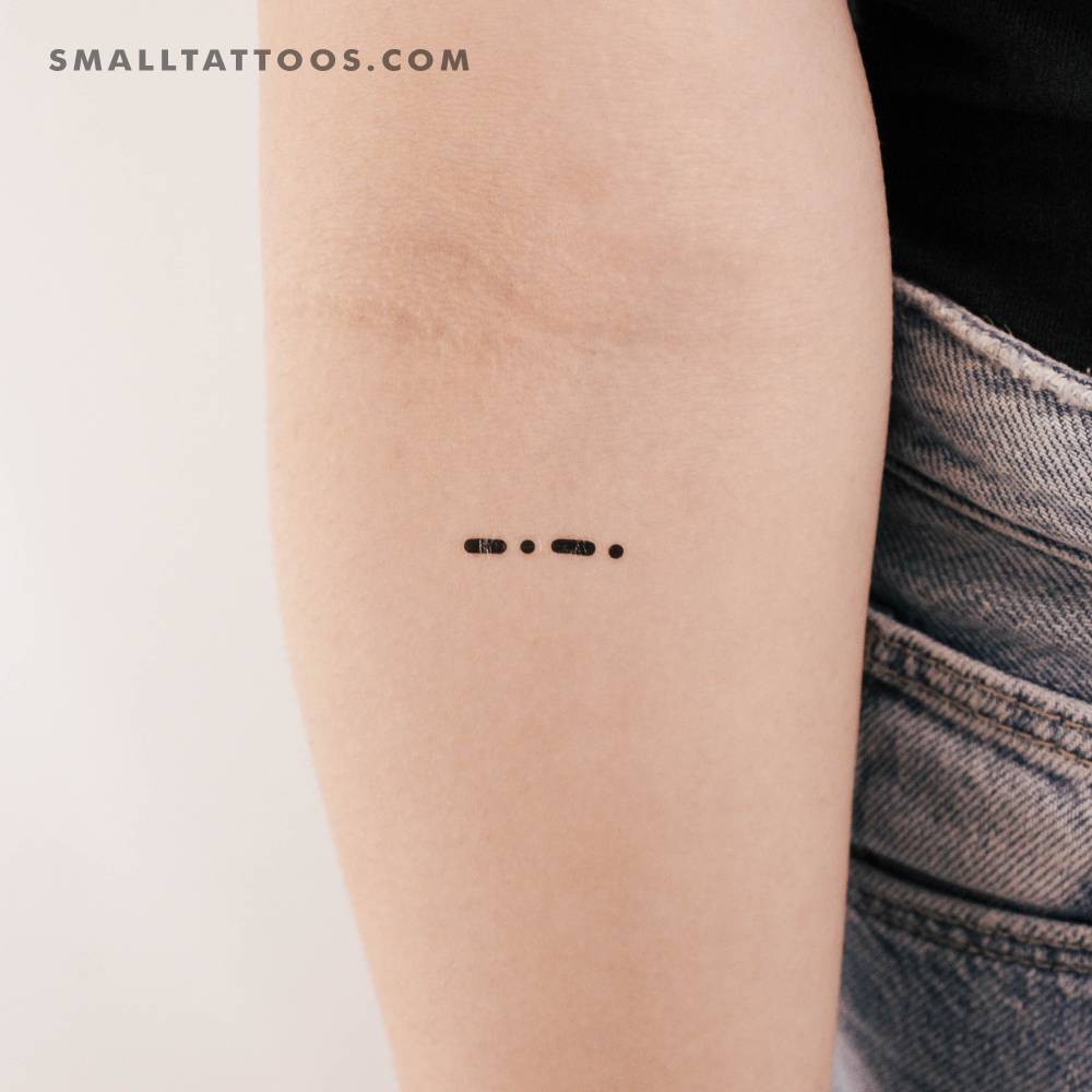 Minimalistic style morse code C temporary tattoo placed on the inner forearm.