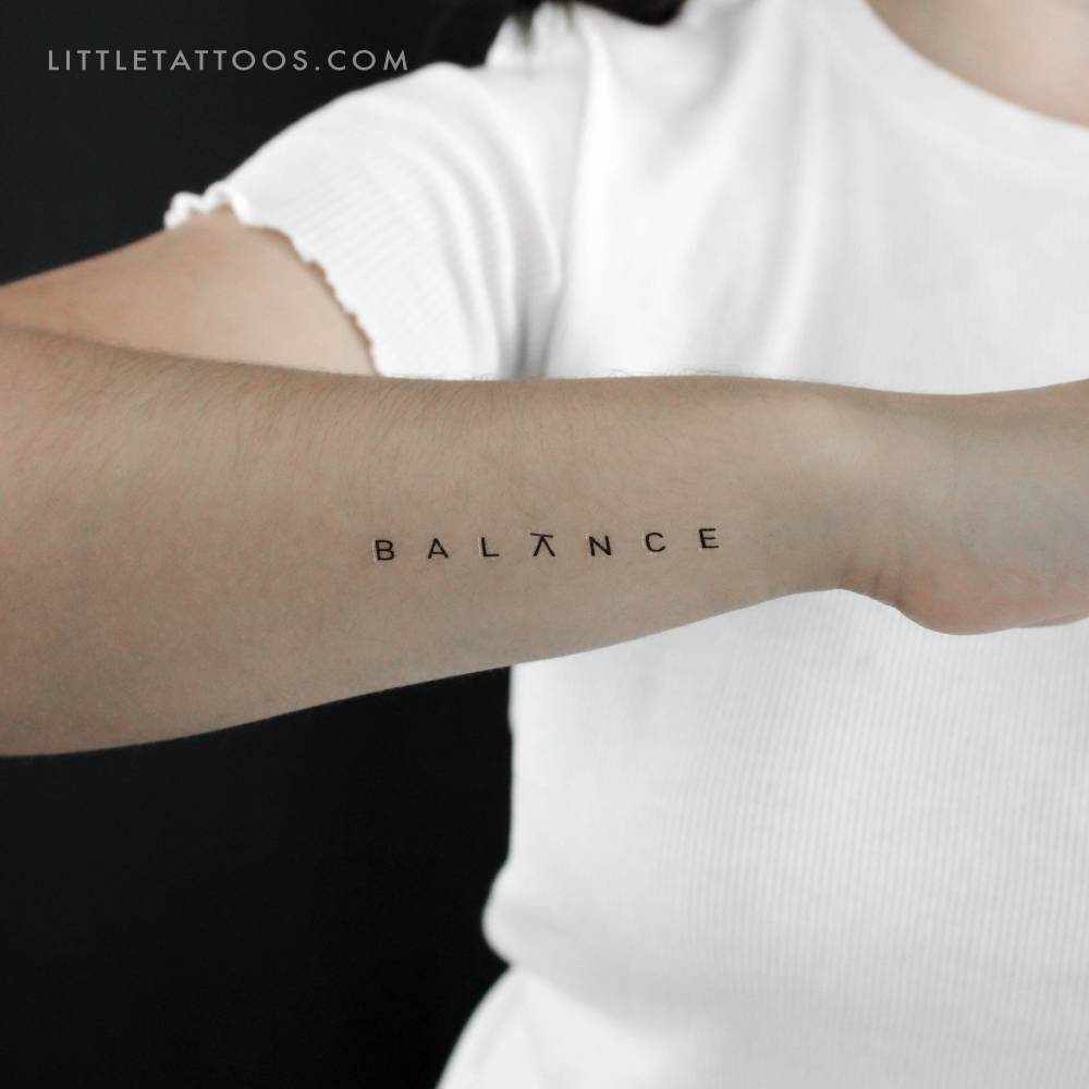 Word "BALANCE" temporary tattoo located on the wrist.