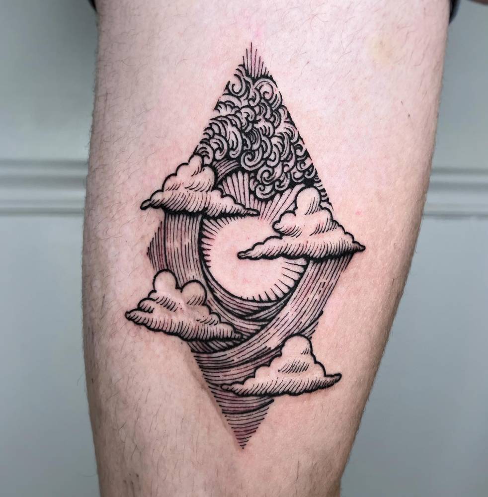 Engraving style waves and clouds tattoo located on the inner arm.