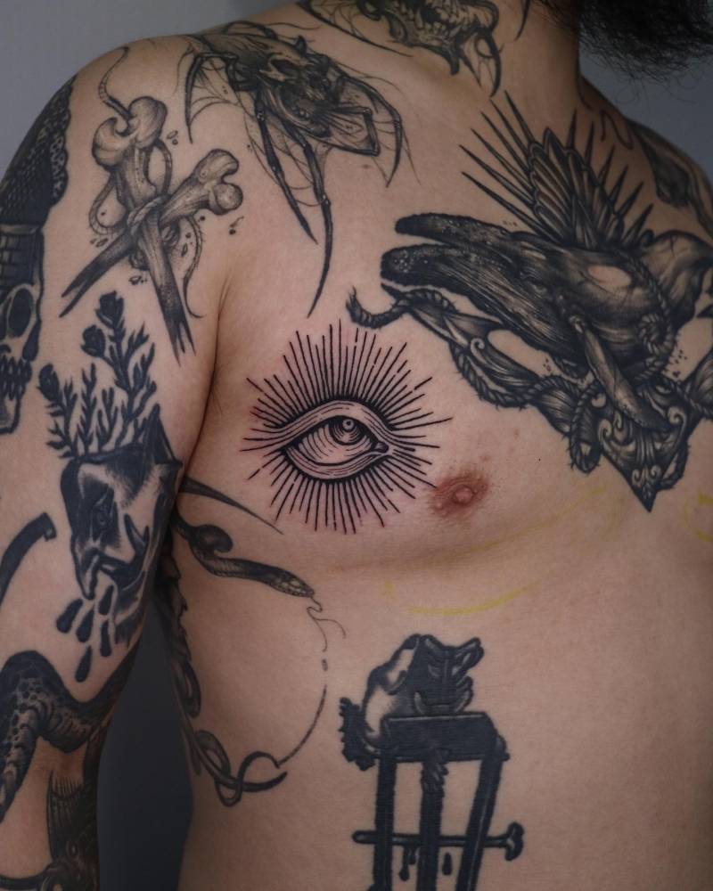 Gap filler eye tattoo in engraving style done on the breast.