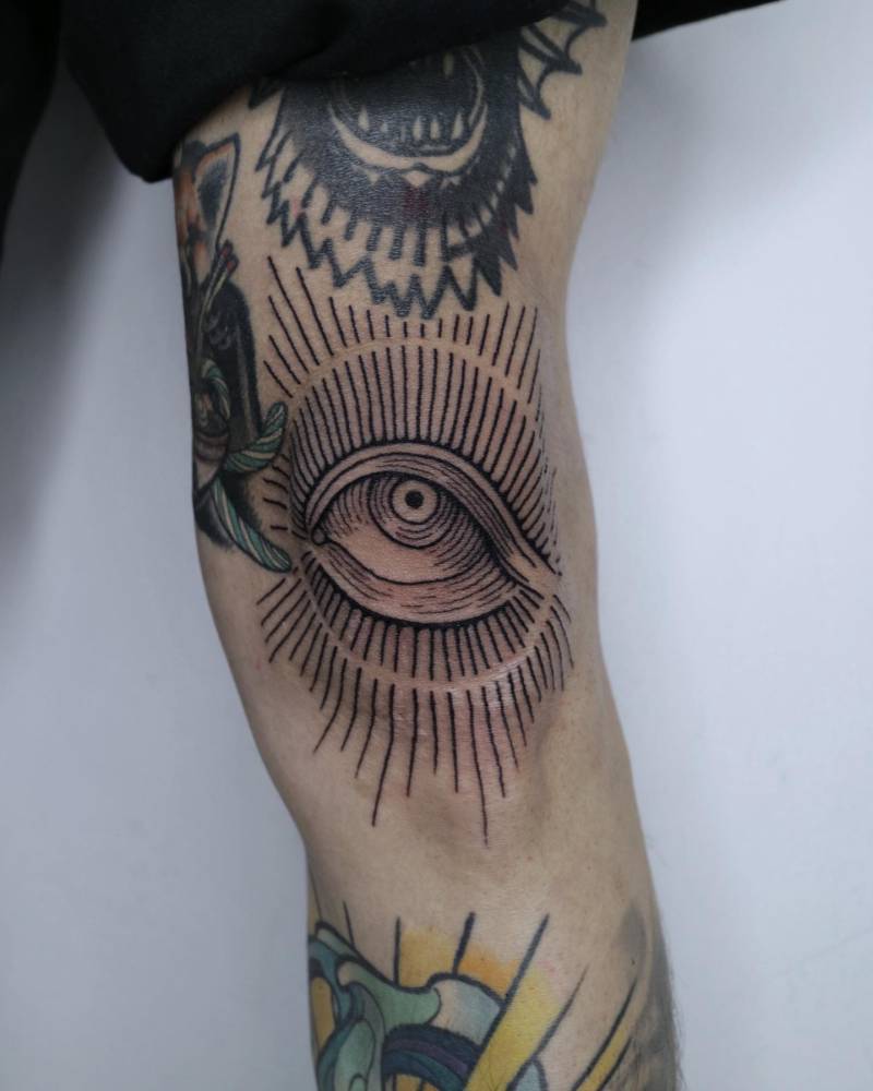 Engraving style eye tattoo located on the knee.