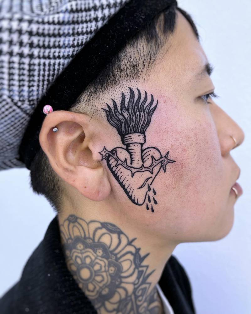 Sacred heart tattoo in engraving style, placed on the face,