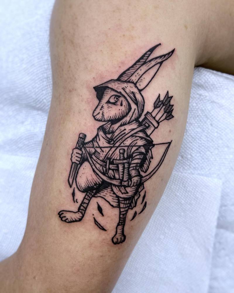 Archer rabbit tattoo in engraving style located on the inner arm.