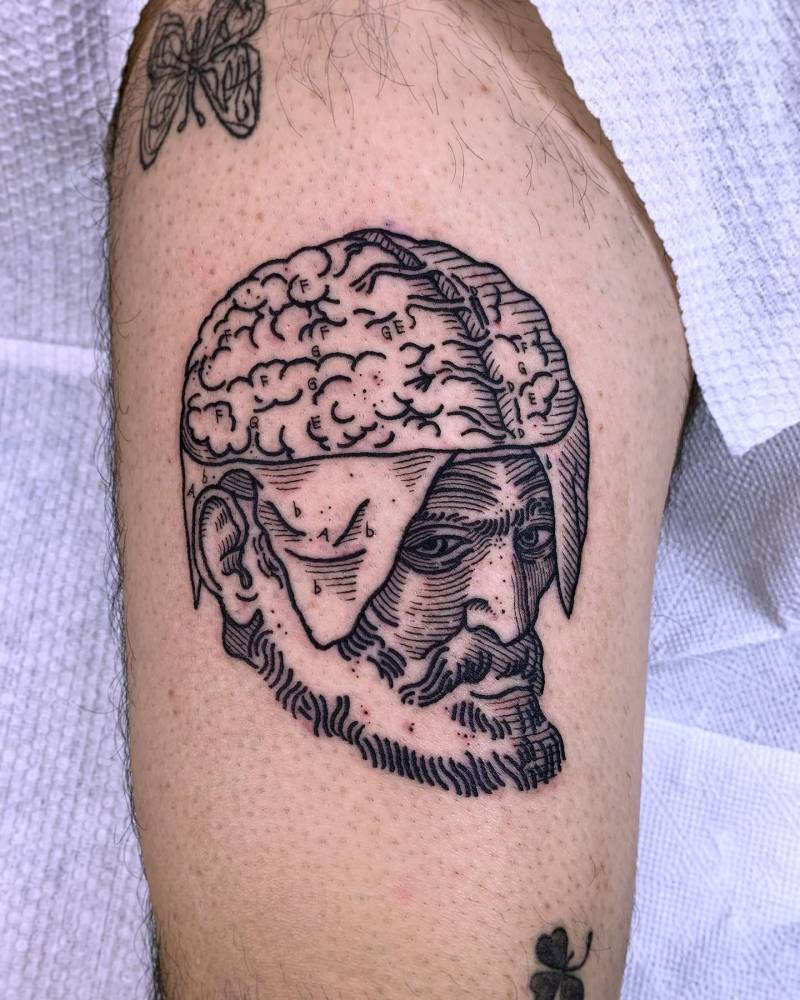 Head scientific illustration tattoo located on the thigh, engraving style.