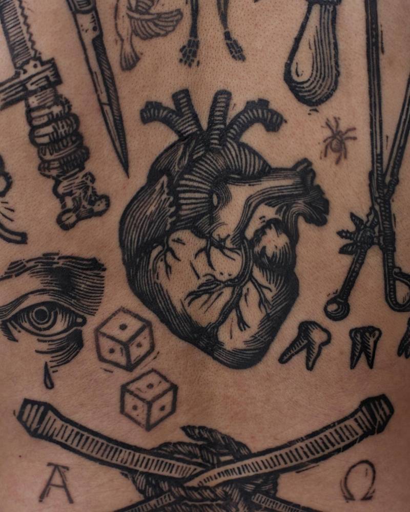Anatomical heart gap filler tattoo in engraving style placed on the back.