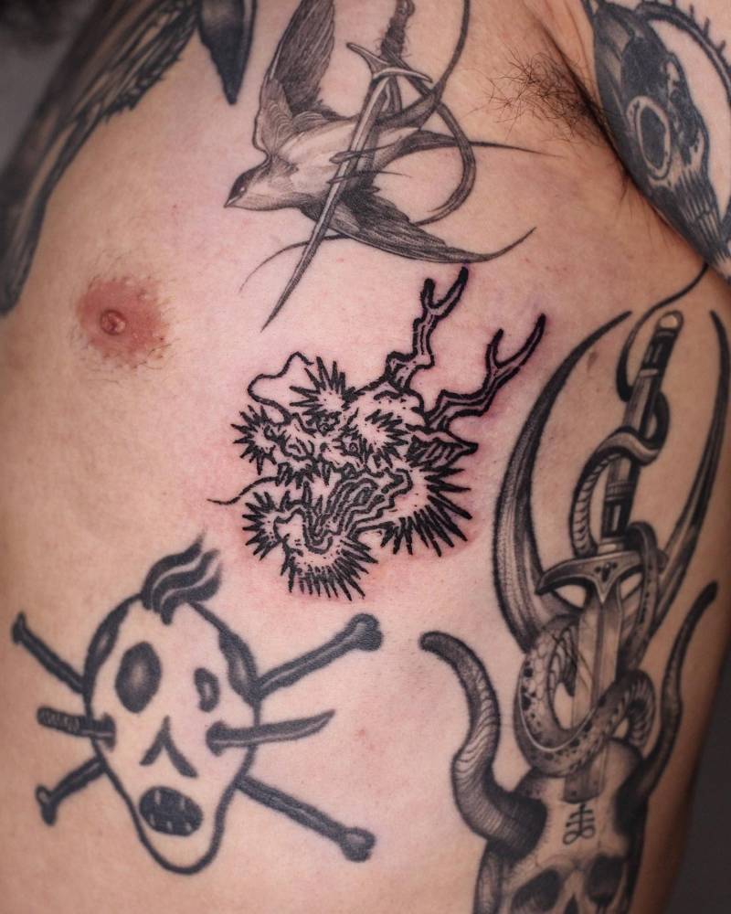 Engraving style dragon portrait tattooed on the side boob.