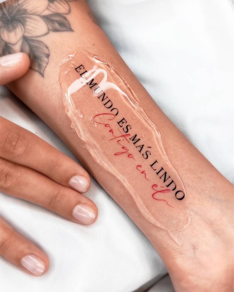 "El mundo es más lindo contigo en él" lettering tattoo located on the wrist.