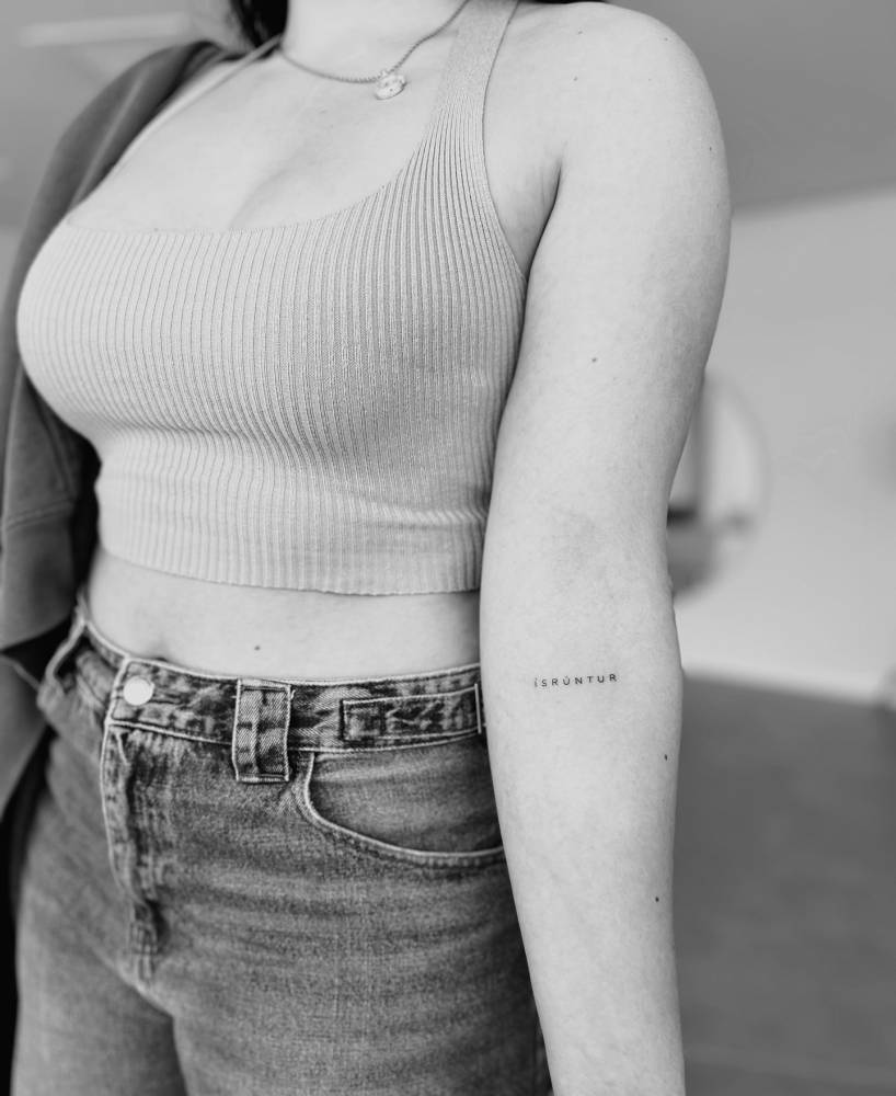 "Ísrúntur" lettering tattoo located on the inner forearm.