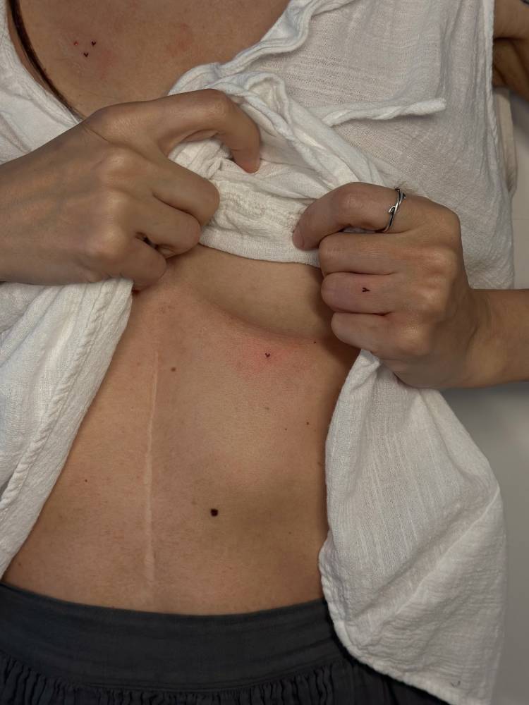 Tiny heart freckle tattoo located on the under boob.