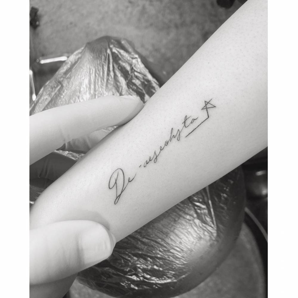Name tattoo in handwritten font located on the wrist.
