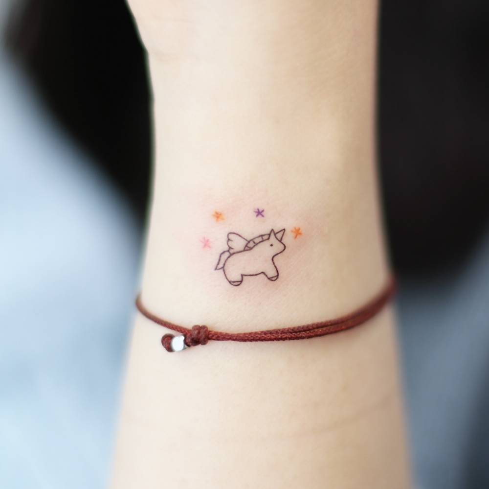Minimalistic style unicorn tattoo located on the wrist.