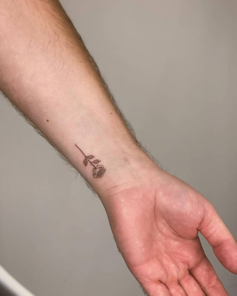 Rose tattoo in fine line style located on the wrist.
