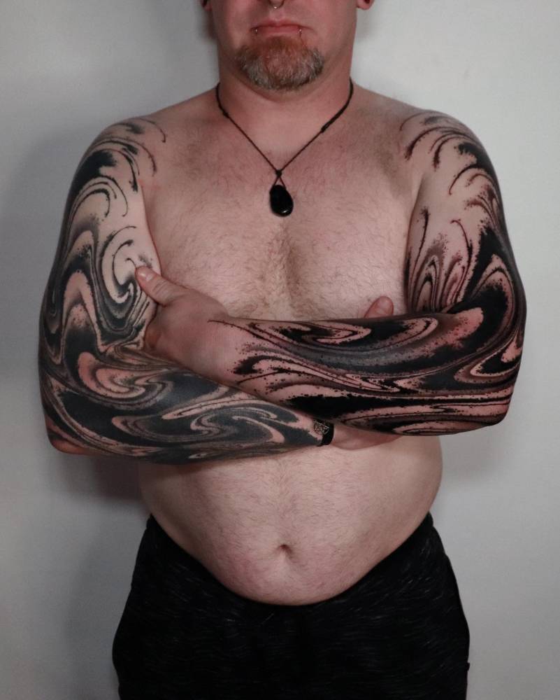 Individual matching abstract tattoo sleeve in blackwork style (one fresh, one healed).