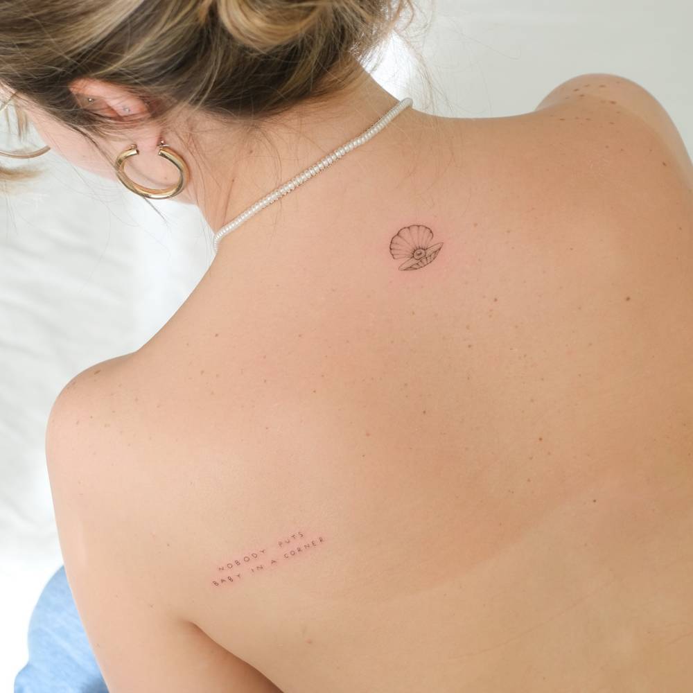 Single needle scallop tattoo located on the upper back.