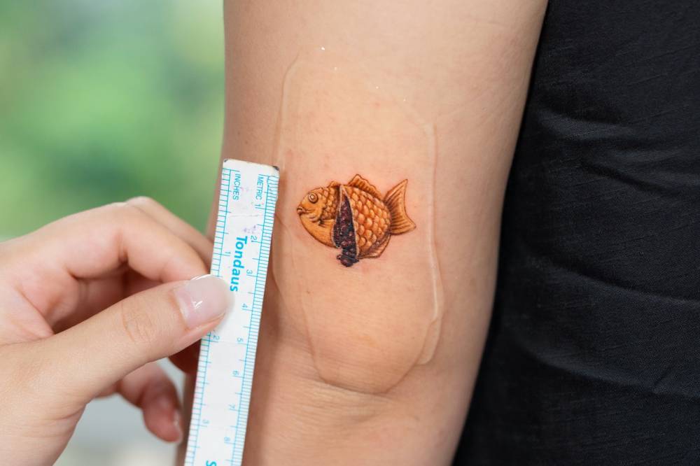 Taiyaki tattoo in micro-realistic style done on the tricep.
