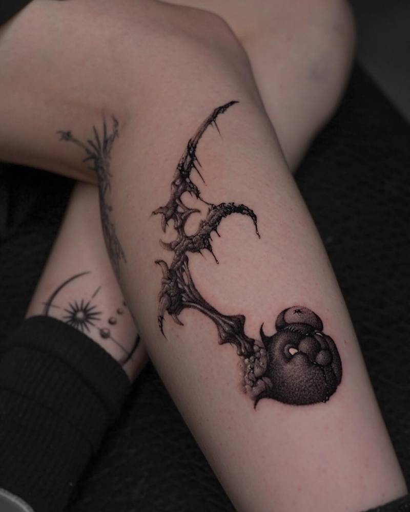 Teddy bear and thorns tattoo located on the shin, dotwork style.