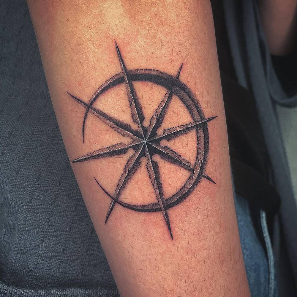 Crescent moon and star tattoo located on the forearm.