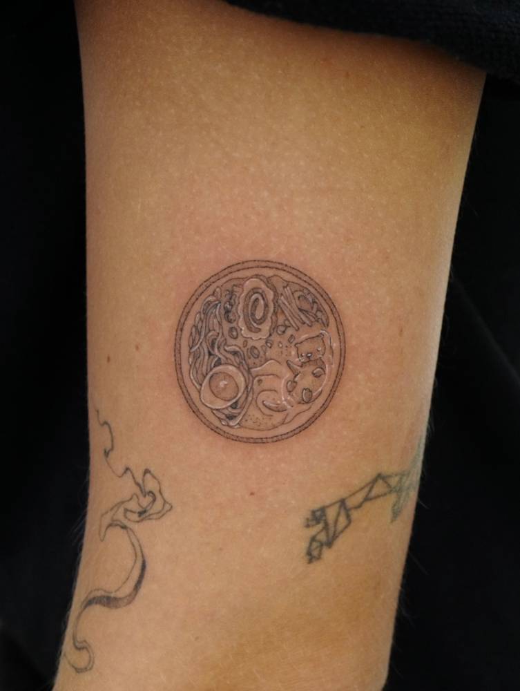 Ramen tattoo located on the inner arm, done in illustrative style.
