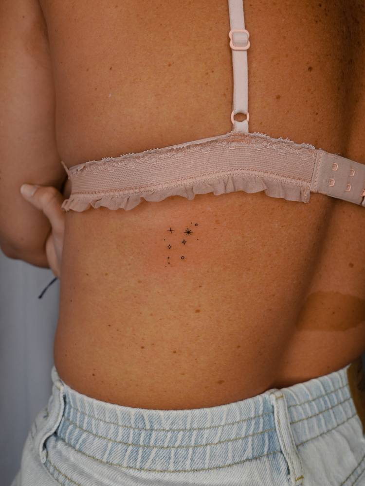 Minimalistic style star collection tattooed on the back.