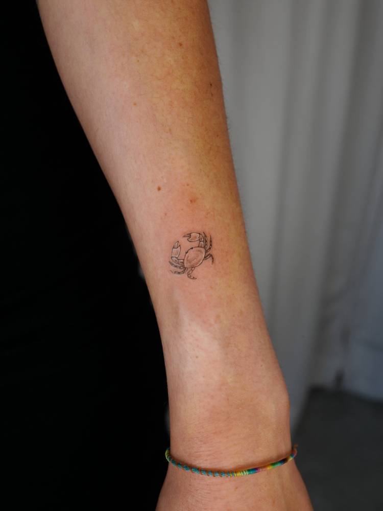 Illustrative style crab tattoo done on the wrist.