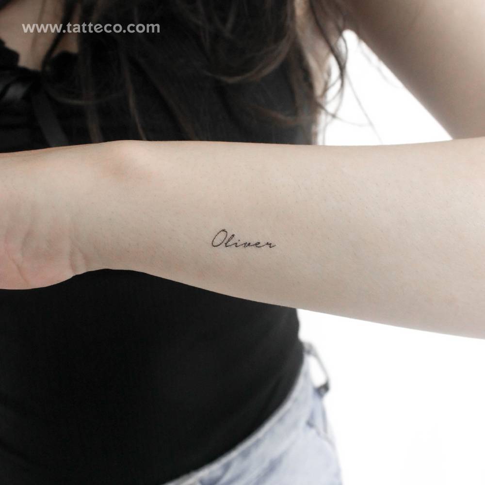 Small name "Oliver" temporary tattoo located on the wrist.