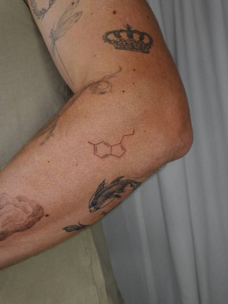 Serotonin chemical structure tattoo located on the forearm.