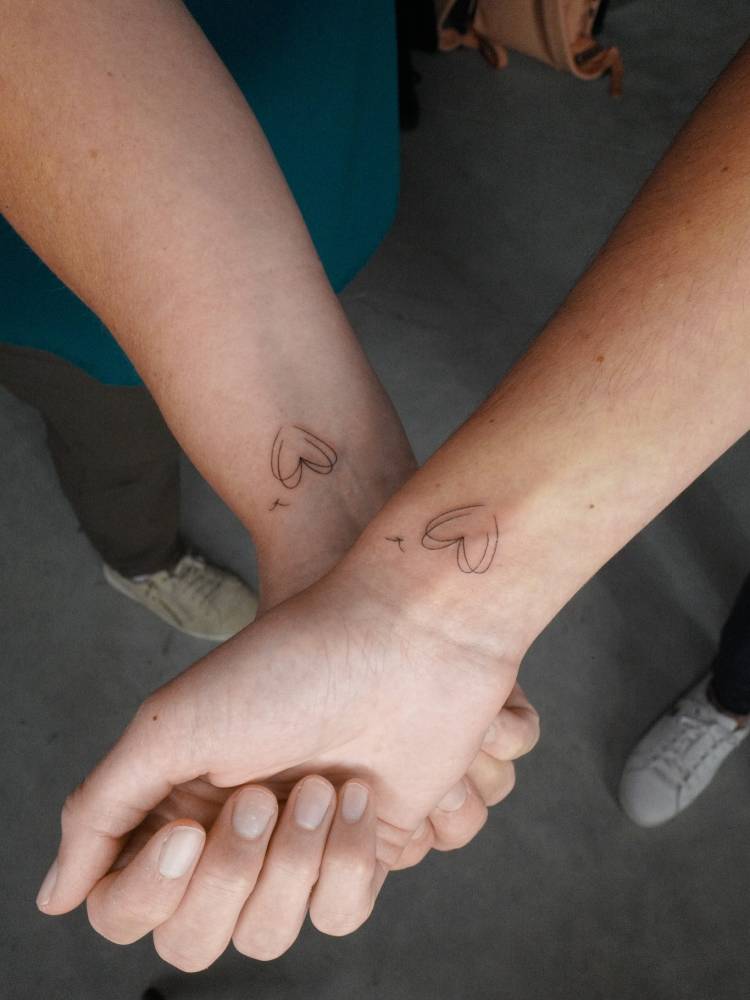 Matching hearts tattoo for best friends, fine line style.
