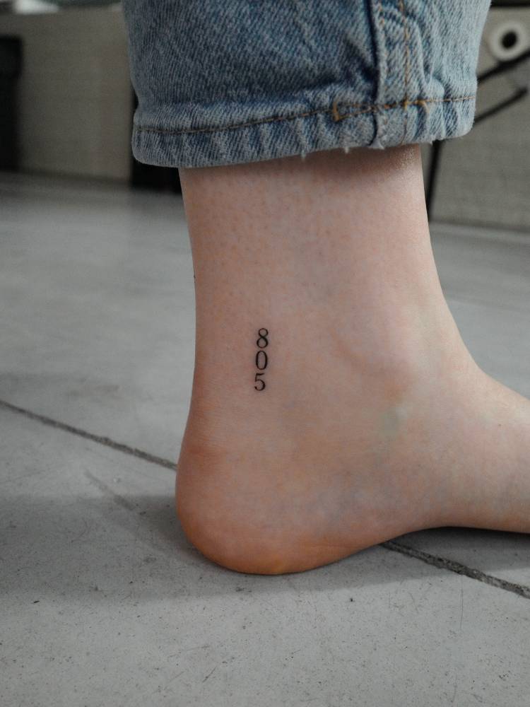 Little tattoo of the number "805" located on the ankle.