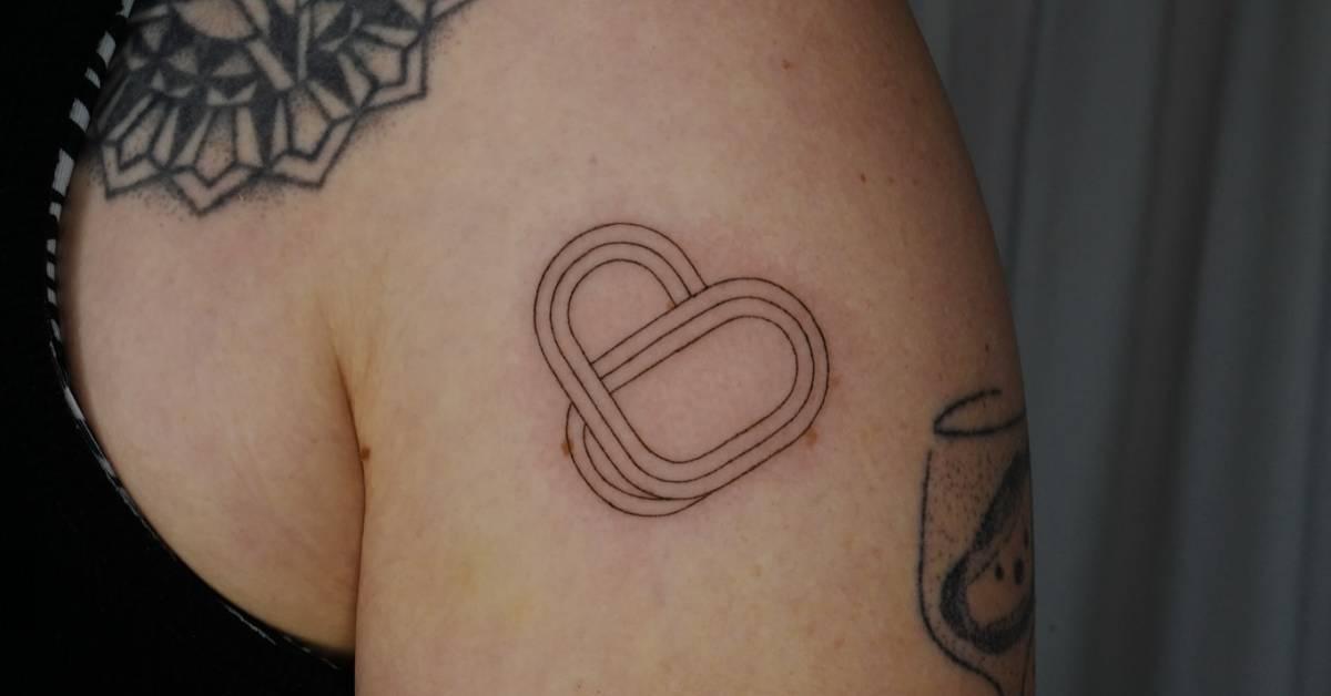 Heart tattoo in fine line style located on the upper