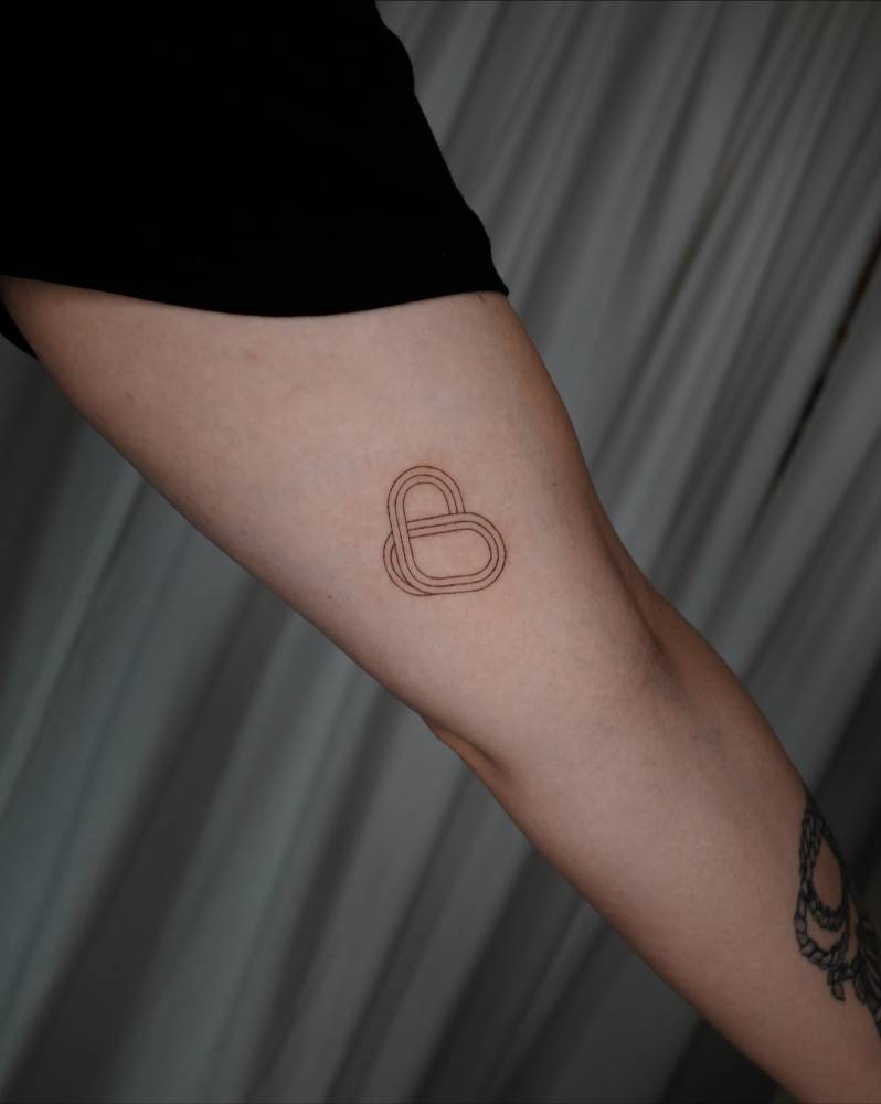 Heart tattoo in fine line style located on the inner arm.