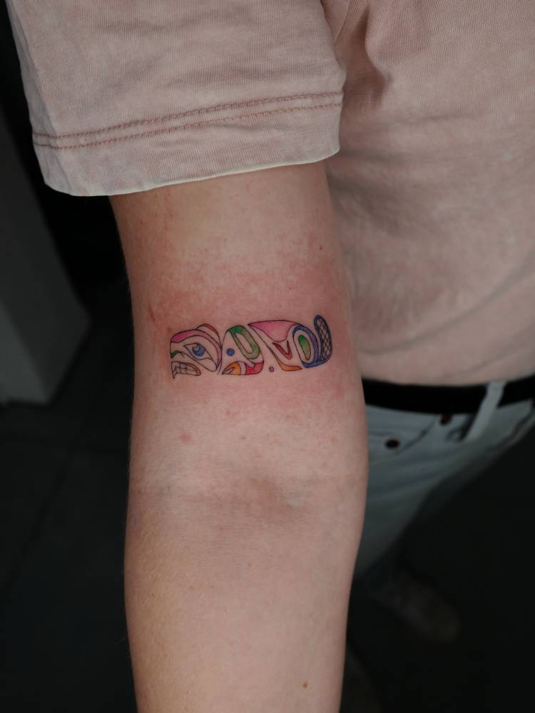 Colorful abstract tattoo located on the bicep.