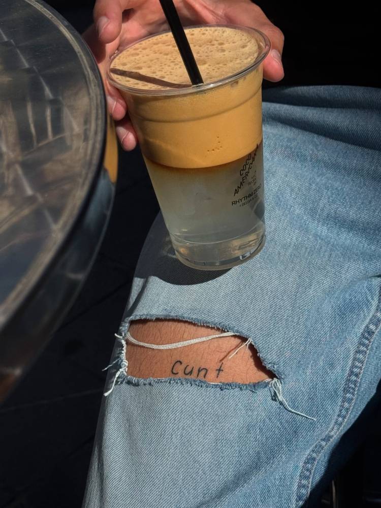 Healed lettering tattoo of the word "cunt" located on the thigh.