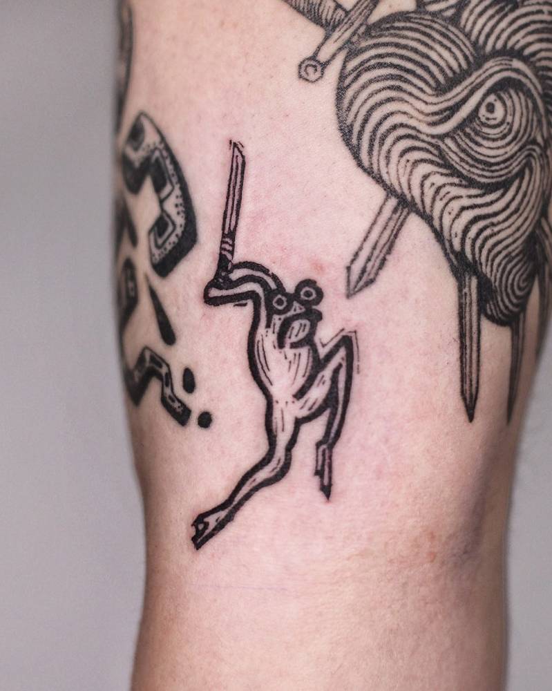 Assassin frog tattoo located on the inner arm.