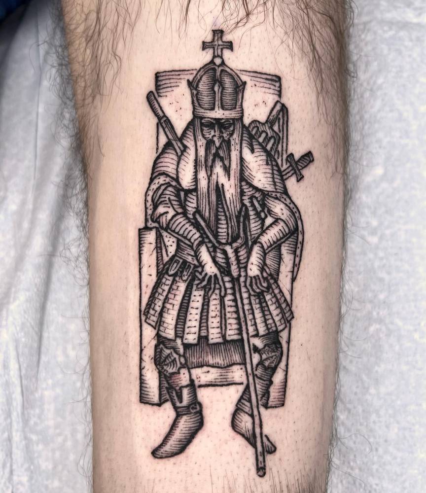 Engraving style king tattoo placed on the thigh.