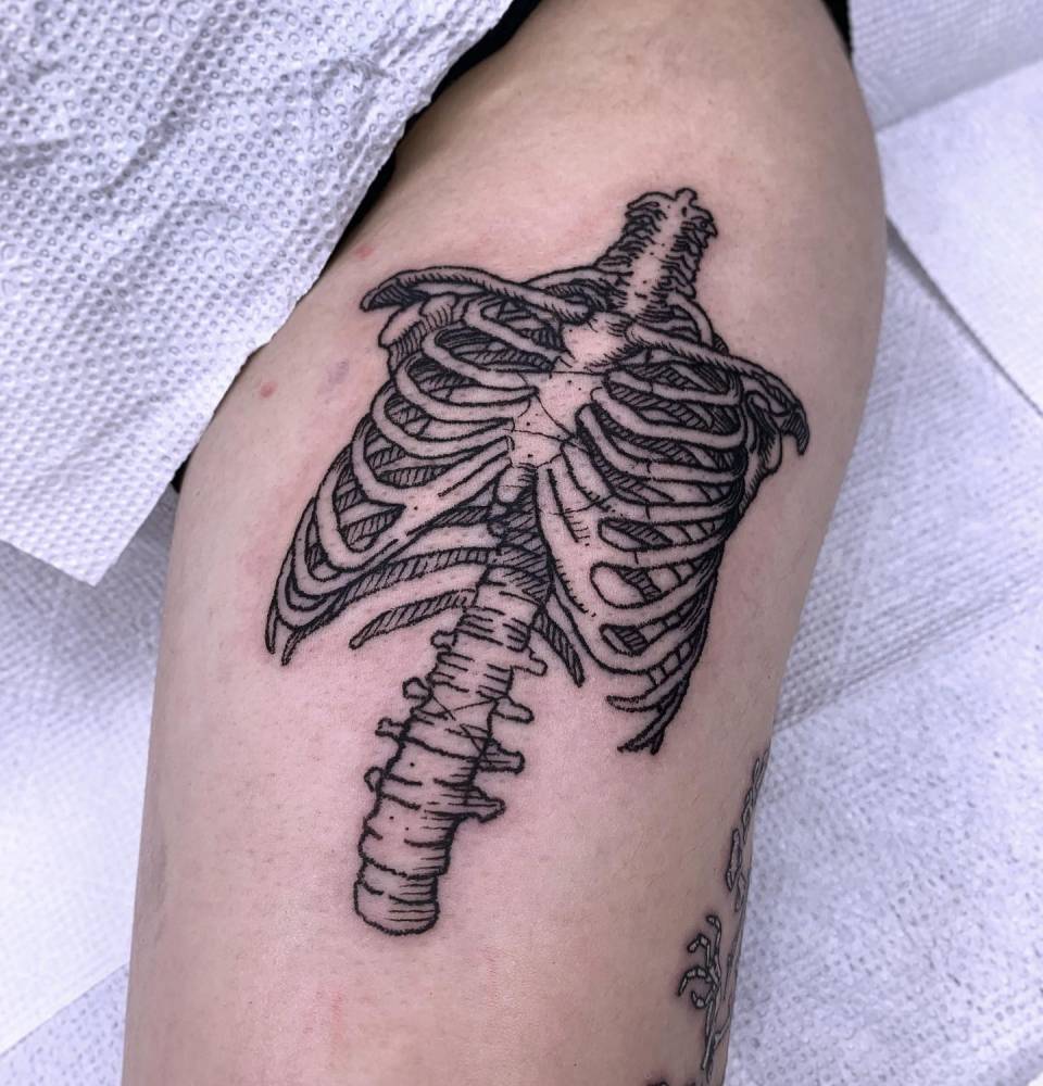 Skeleton tattoo located on the thigh, engraving style.