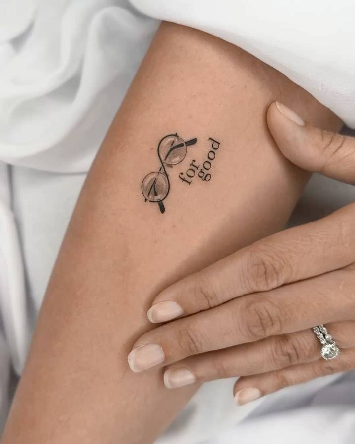 Harry Potter's eyeglasses and words "for good" tattooed on the inner forearm.