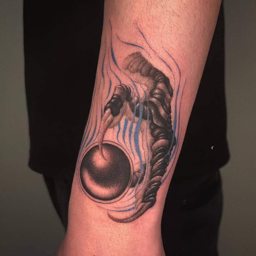 Dragon claw tattoo in dotwork style located on the wrist.