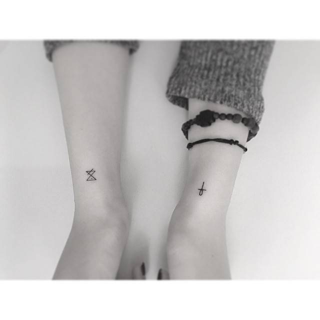 Dagaz rune and Ankh tattoos located on the wrists, minimalistic sytle.