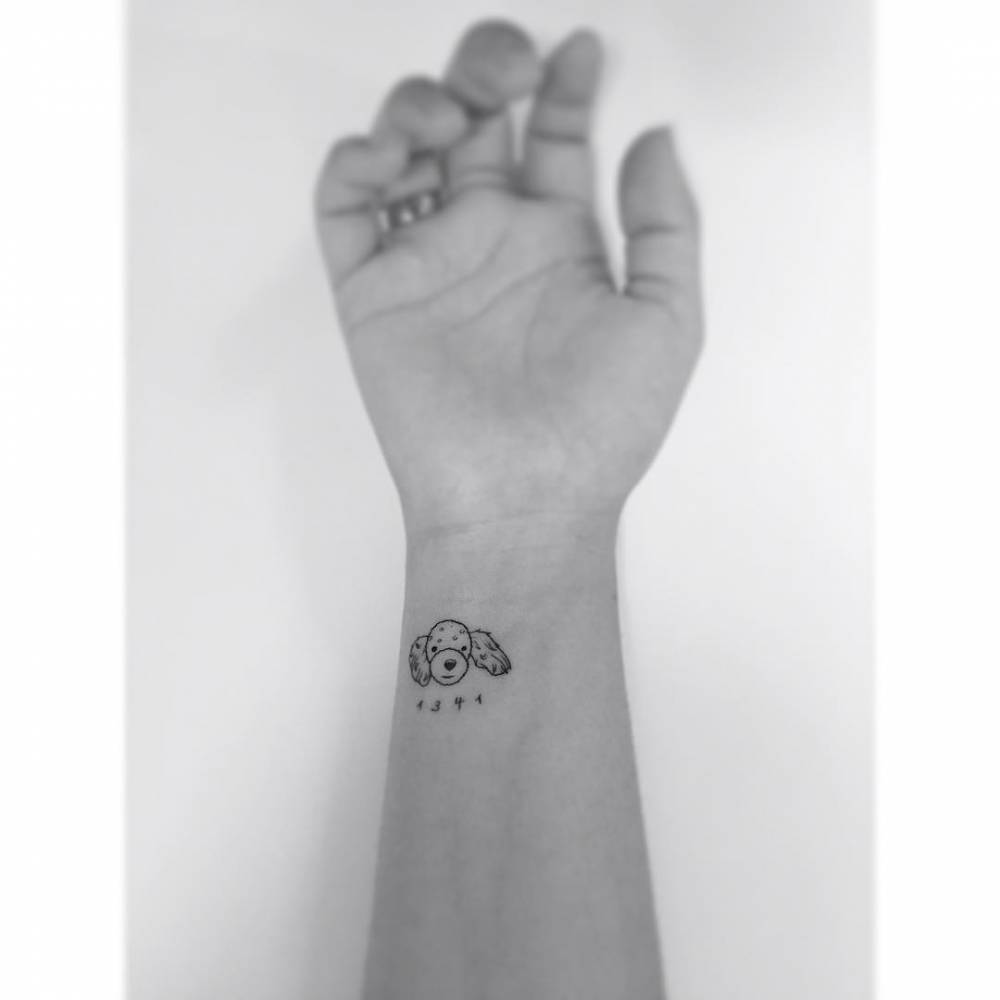 Poodle portrait tattoo in minimalistic style placed on the wrist.